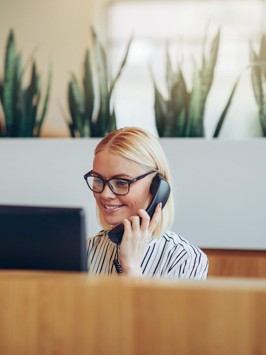 En som sitter i receptionen och svarar i telefonen- Facility management
