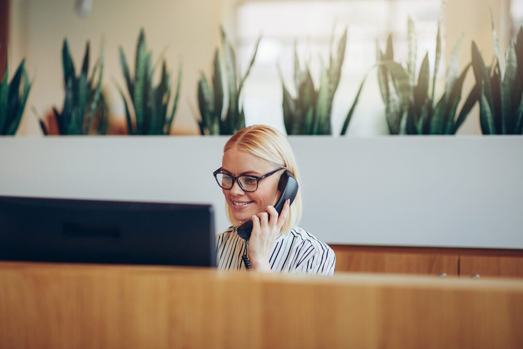En som sitter i receptionen och svarar i telefonen- Facility management