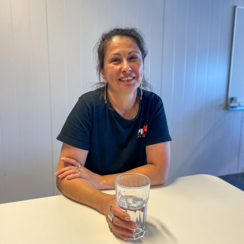 Maggie sitter ner med glas